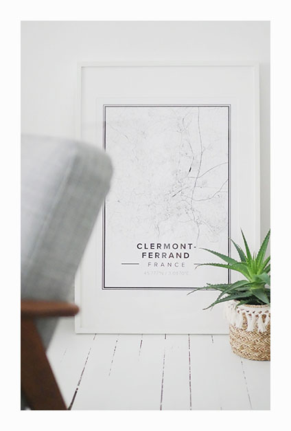 affiche de clermont-ferrand avec plante devant sur parquet blanc