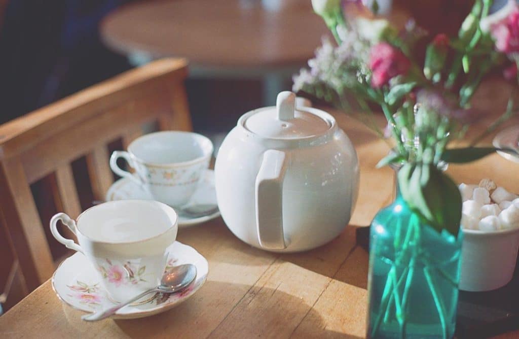 tasses et théière posées sur une table dans un salon de thé