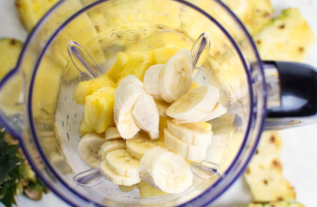 Banane et ananas coupés en morceaux dans un blender
