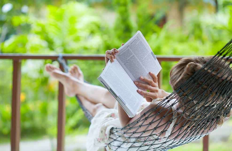 Femme lisant dans un hamac